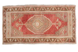 Distressed vintage Oushak rug, concentric medallion, geometric borders, faded cherry red, beige, bronze.