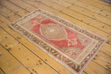 Stemmed plant finial and checkered border on a distressed vintage Oushak rug.