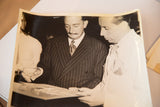 Salvador Dali in pinstriped suit, reviewing dream sequence design drawings on set.