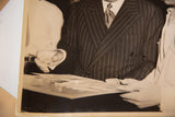 Vintage black and white photo detail: hands viewing design drawings for film dream sequence.