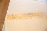 Aged, torn typed description visible on the back of the vintage photograph.