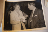 Angled vintage black and white photo of Ingrid Bergman and a gentleman conversing.