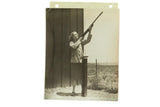 Vintage Carole Lombard photograph shooting a rifle at a skeet range, sepia-toned.