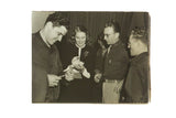 Vintage candid photograph of a smiling Ingrid Bergman signing autographs for a group of fans.