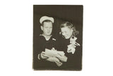Vintage candid photograph of actress Ingrid Bergman smiling while signing an autograph for a sailor.