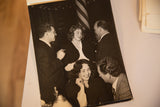 Candid moment of Ingrid Bergman smiling, conversing with companions in vintage photograph.