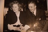 Producer David Selznick and actress Ingrid Bergman laughing together in a candid vintage photograph.