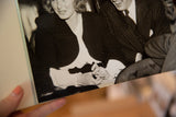 Angled close-up on the vintage photograph showing Bergman's hands and Selznick's pinstripe suit.