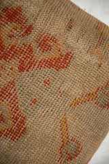 Close-up of vintage Turkish rug fragment weave, showing storied texture and muted orange, beige.