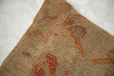Vintage Turkish rug fragment pillow: woven texture with muted orange, gold, and earthy tones.