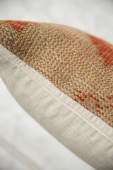 Vintage Turkish rug fragment pillow's coarse brown, orange weave and cream fabric backing.