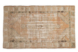 Distressed Vintage Oushak rug with faded terracotta, beige, and olive hues, featuring a medallion.