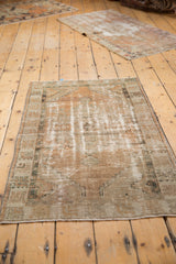 Distressed vintage Oushak rug pile with mostly even wear, revealing ivory foundation.