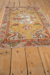 Distressed Oushak runner corner with faded gold, red geometric border, short fringe.