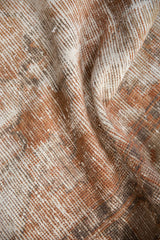 Distressed vintage Oushak runner's textural pile in faded terra cotta and ivory.
