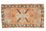Distressed vintage Oushak runner with tangerine orange field, ivory medallion, and serrated geometric patterns.