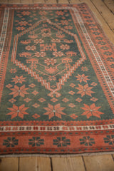 Distressed vintage Oushak rug, close-up showing faded teal field with geometric terra cotta motifs.