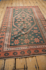Faded dusty teal and copper geometric starburst patterns on a distressed vintage Oushak rug.