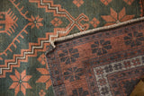 Detail of distressed Oushak rug's faded teal pile and hand-knotted rust foundation.