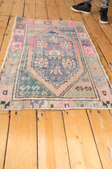 Soft pink and seafoam green serpent spandrel detail on the distressed Oushak rug.