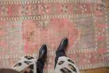 Distressed vintage Turkish Oushak rug; dusty pink, silver, bronze plant motifs and softened texture.