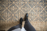 Vintage distressed Oushak carpet, with denim blue and ivory trellis motif and visible wear.