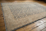 Faded denim blue and ivory trellis motif on a distressed vintage Oushak carpet.