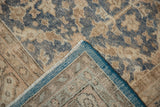 Distressed Oushak rug corner showing worn denim blue pile, blue selvage, and woven back.