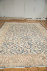 Softened denim blue and ivory covered trellis motif on a distressed Oushak rug.