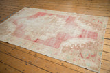 Distressed Oushak rug corner detailing low pile, visible foundation, pearl motifs, and soft colors.