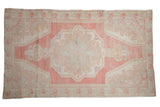 Distressed Oushak rug, large center medallion, pearl motifs, in rose, blush, ivory, and beige.