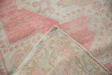 Hand-knotted foundation and selvage detail of vintage distressed Oushak rug with blush and ivory pile.