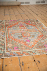 Distressed Oushak rug pile texture detail with worn terra cotta, pale blue, pink tones.