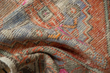 Distressed Oushak rug detail showing textured pile with pale blue, terra cotta, and mint green.
