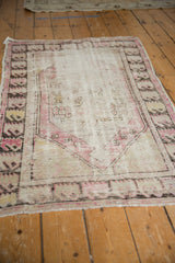 Worn short fringe and faded plum, charcoal geometric border on vintage Oushak rug.