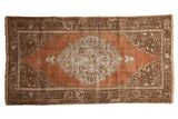 Distressed vintage Oushak rug with faded floral medallion, abrashed rust field, brown border, 2'10