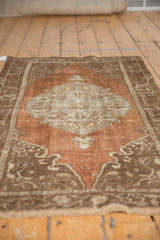 Decorative distressed Oushak rug featuring a worn medallion and muted chestnut, chocolate, and silver tones.