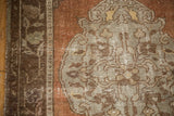 Detail of a vintage distressed Oushak rug showing chestnut brown and silver germinating floral motifs.