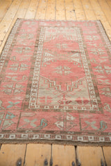 Distressed Oushak rug showing soft pile, chocolate border, dusty blush, and hook motif.
