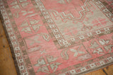 Distressed vintage Oushak rug with dusty blush, ivory patterns and intact side selvage.