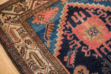 Detailed ivory border of a vintage Hamadan rug with brown and blue geometric motifs.
