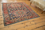 Antique Heriz rug section highlighting serrated main border, stylized leaves, and vinery in dusty navy and coral.