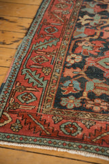 Hand-knotted antique Heriz rug's serrated leaf main border in red, navy, and green.