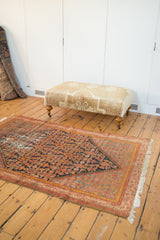 Vintage Persian Malayer rug, angled view highlighting softened Herati motifs in navy, red, saffron.