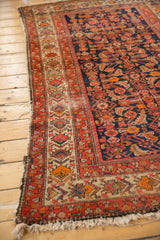 Vintage Malayer rug's geometric main border and Herati motif field, showing low pile.