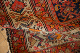 Vintage Malayer rug's hand-knotted pile with tomato red, navy blue, and cream Herati motifs.