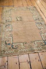 Sand field and teal, sapphire blue border patterns on a vintage Chinese rug.