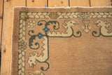 Vintage Chinese rug border: dragons framing a central crest, blue flowers, sand field.