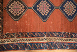 Close view of the running wave border and geometric hook latch gul on an antique Bakshaish rug.