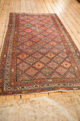 Madder root red and sapphire blue geometric guls, boteh border, and softened texture on antique Kurdish Malayer rug.